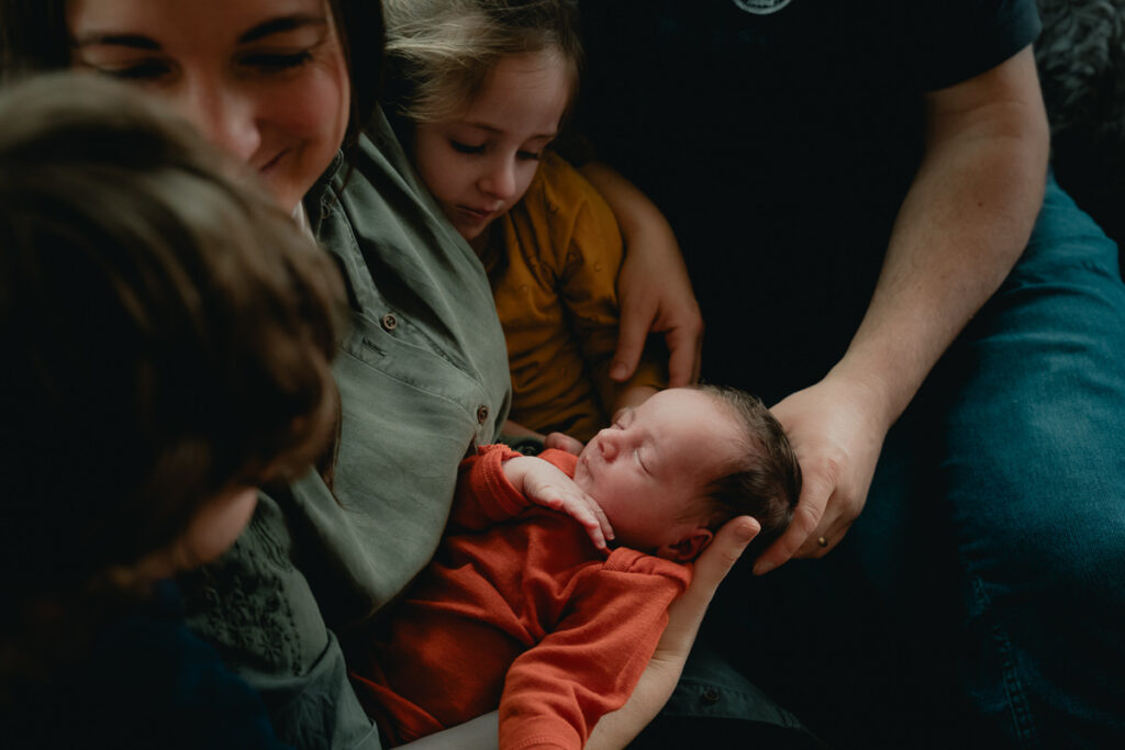 Familie kuschelt mit Neugeborenem beim Neugeborenenshooting im Saarland