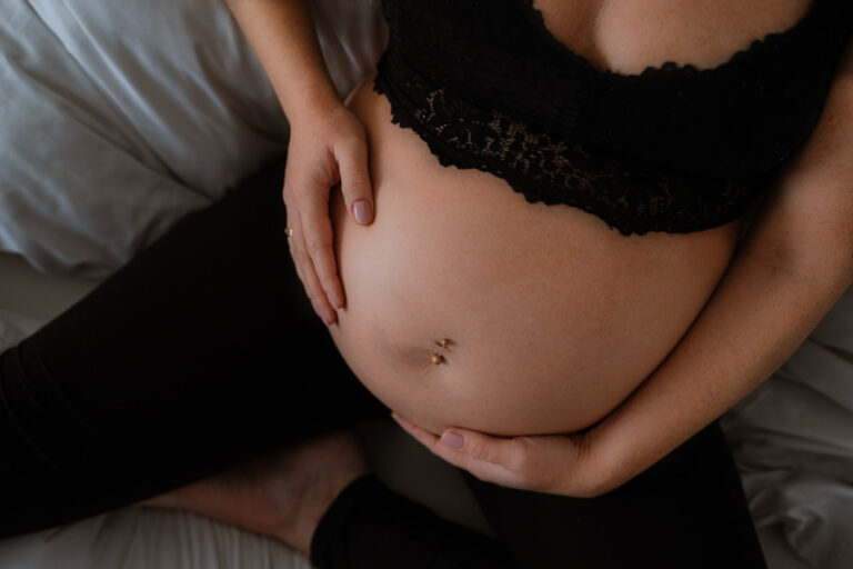 Babybauchshooting in Saarbrücken mit Fokus auf runden Bauch in Spitzen-BH